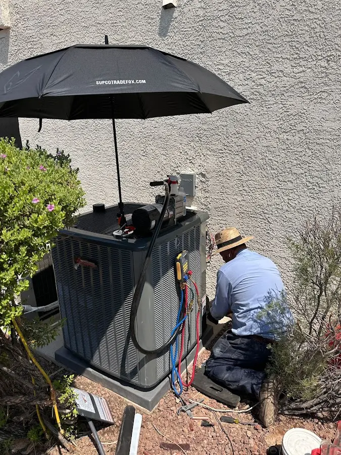 HVAC technician performing outdoor AC maintenance in Thomson